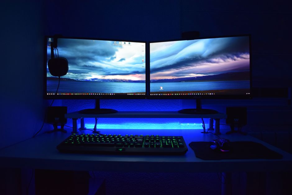 Dual monitors con iluminación azul en un escritorio de trabajo